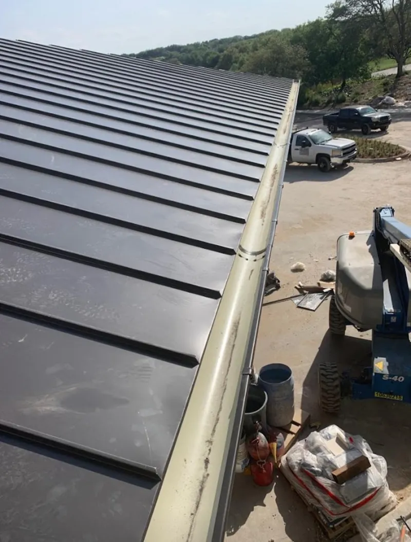 Standing seam panel and gutter detail on a metal roofing jobsite in New Kensington